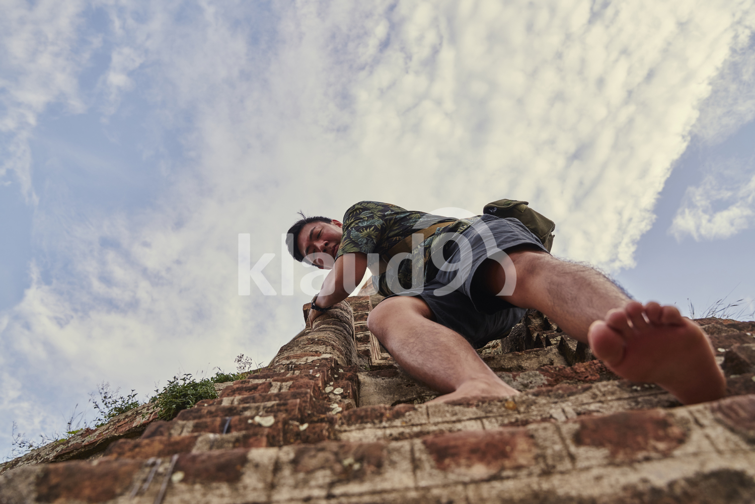 Young Man Climbing Down The Steps Of The Ancient Pyathadar Temple, Bagan, Myanmar