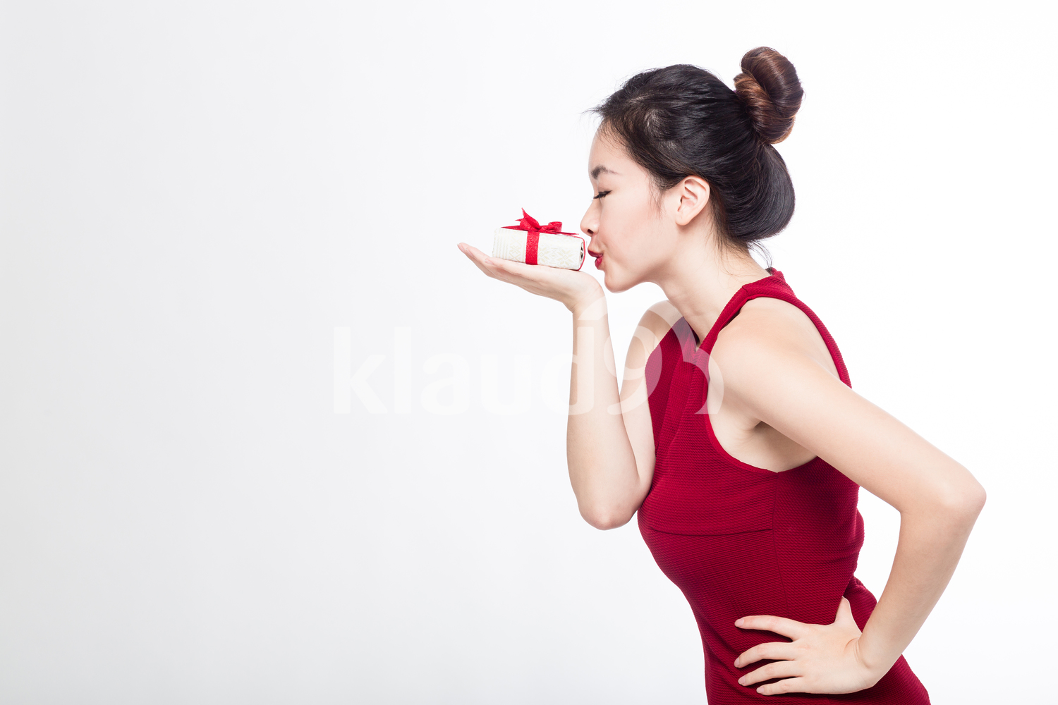 Sideview of a woman kissing her gift box