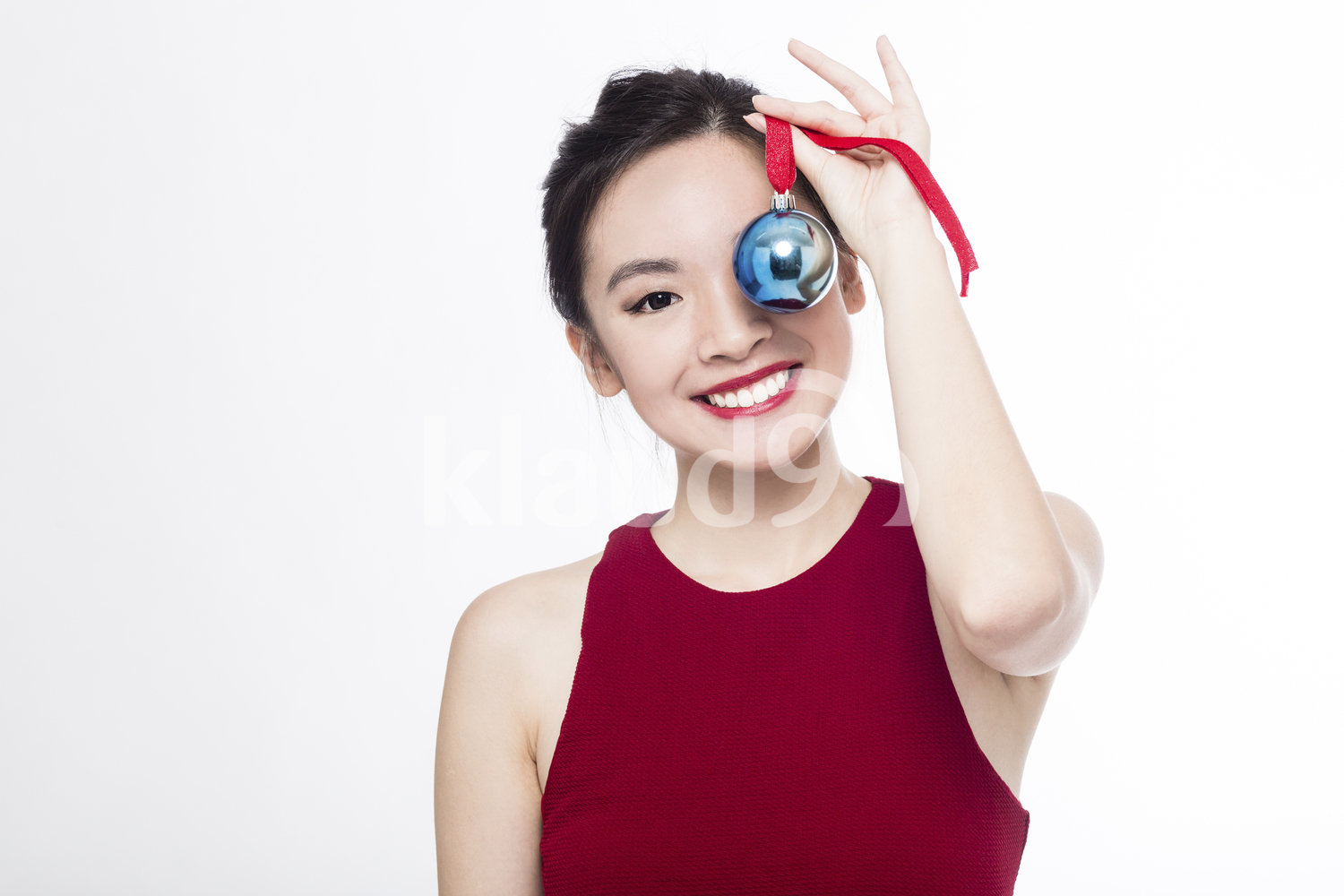 Happy Pan Asian woman with her Christmas ball ornament