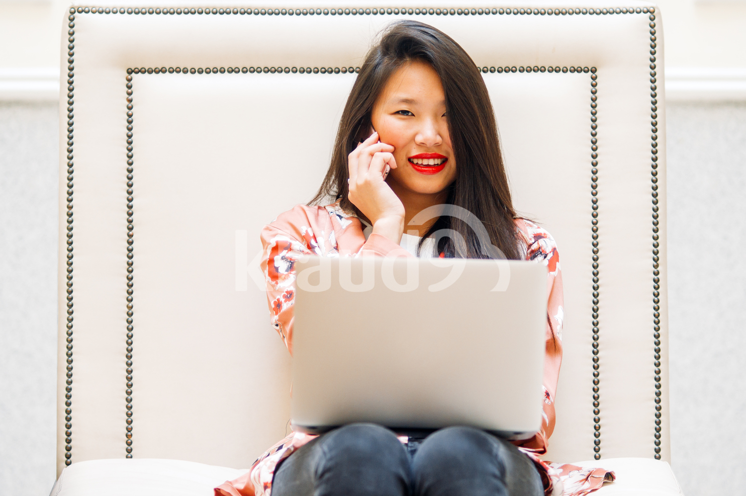 Asian woman on the phone and smiling at the Camera