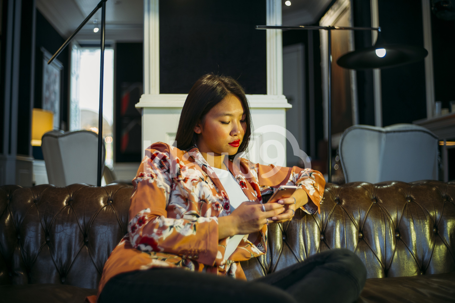Chinese woman at a Cafe browsing her smartphone