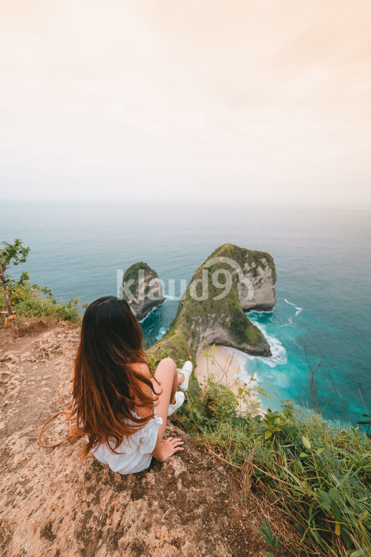 Asian long hair woman sitting on a cliff