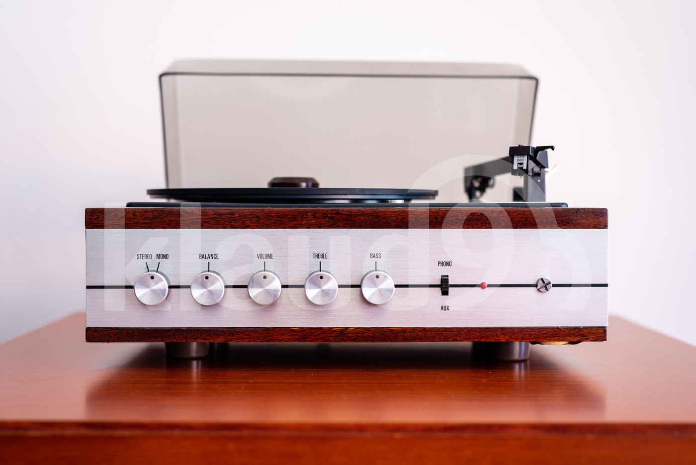 Vintage turntable made of wood and plastic cover on a old table