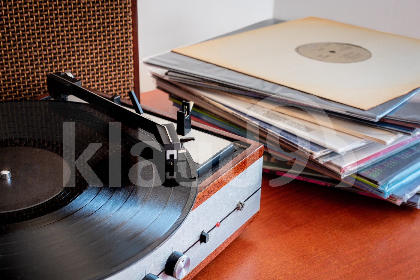Vintage turntable made of wood with speakers and vinyls on a old table 