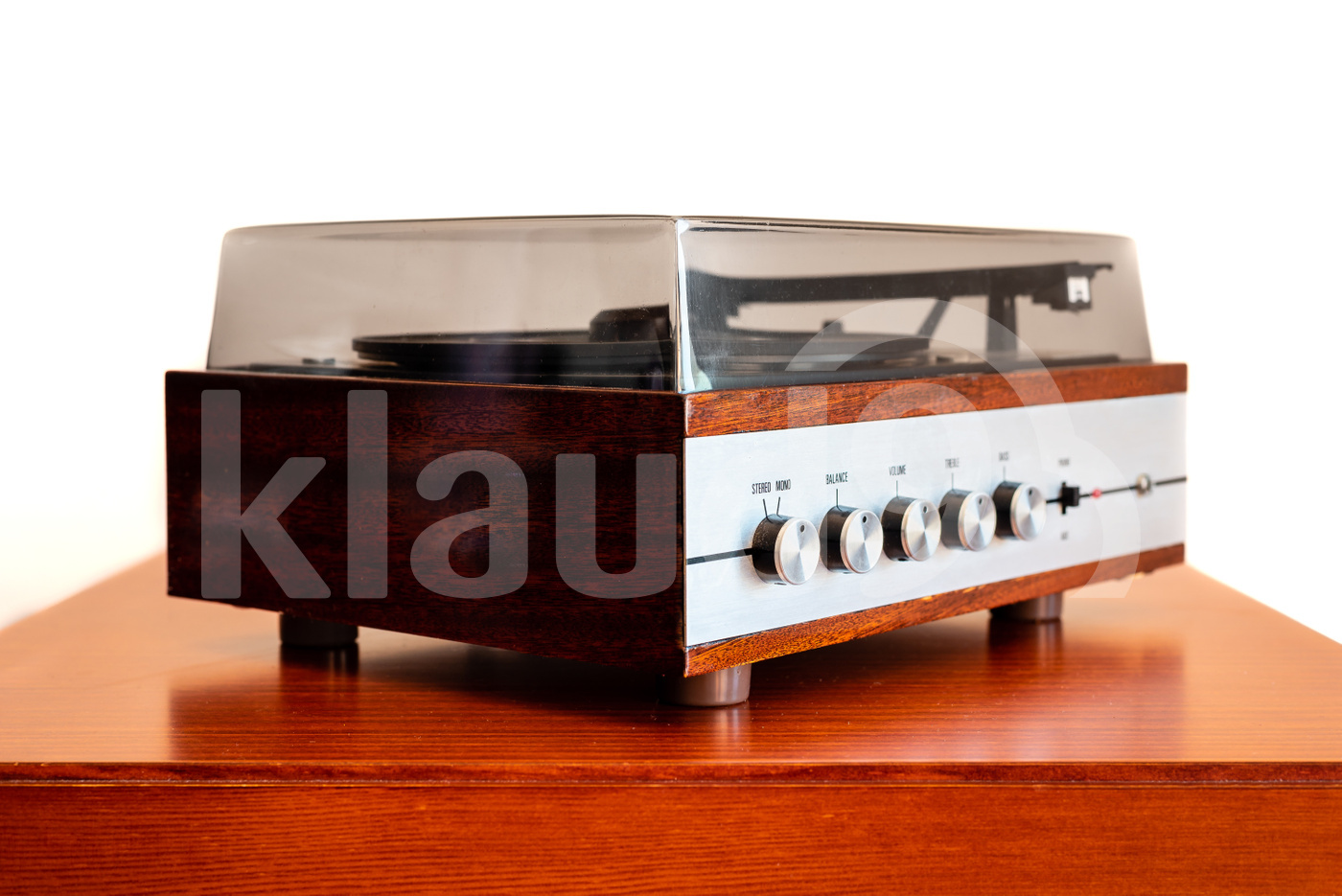 Vintage turntable made of wood and plastic cover on a old table