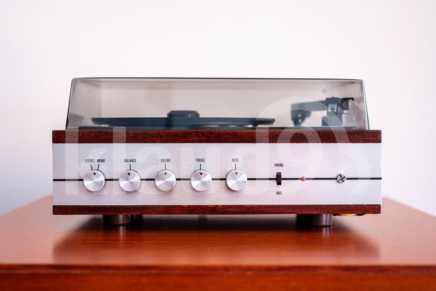 Vintage turntable made of wood and plastic cover on a old table