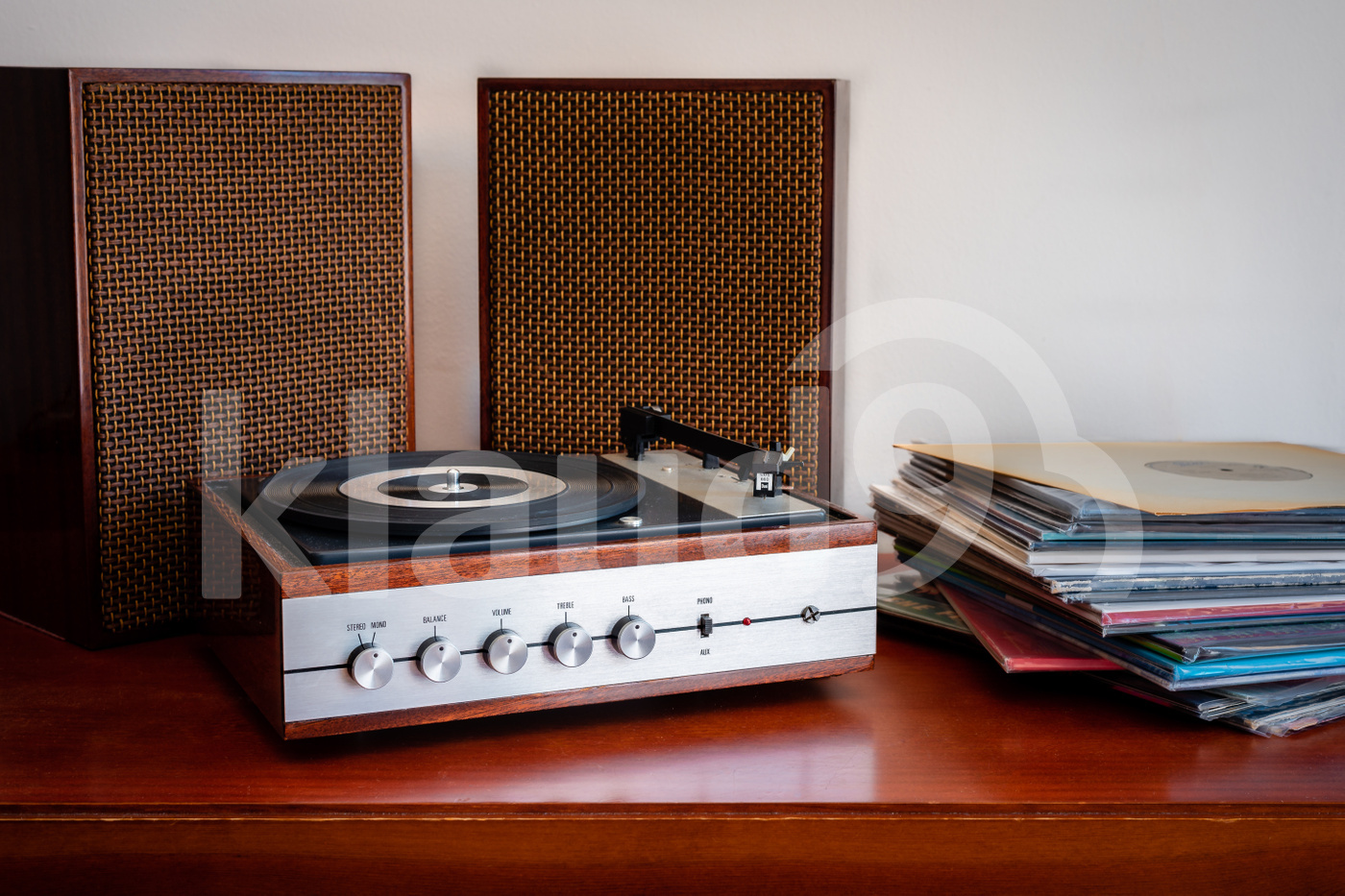 Vintage turntable made of wood with speakers and vinyls on a old table 
