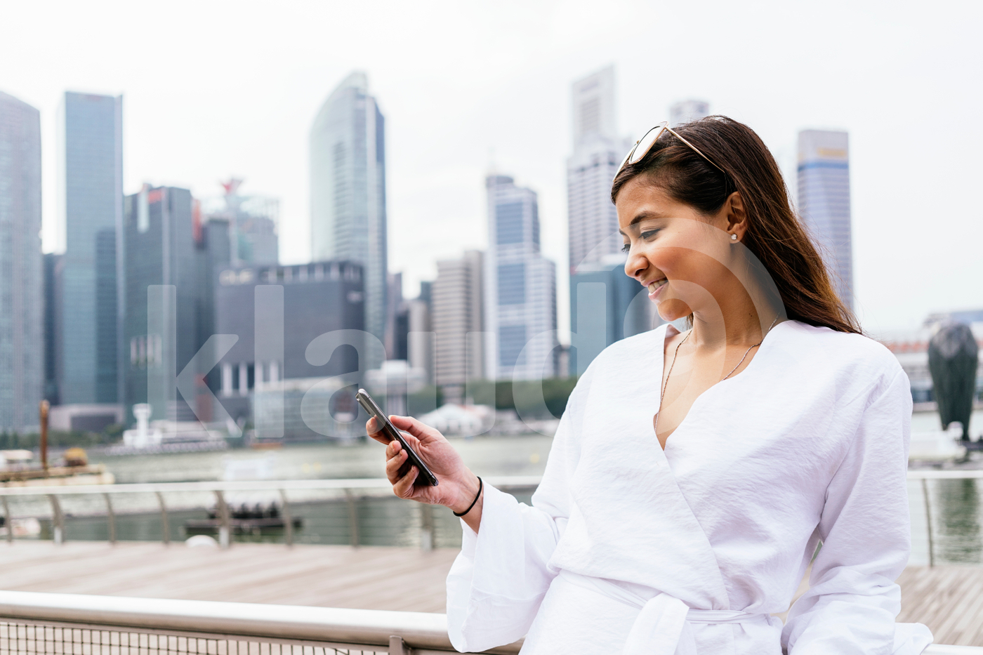 Asian woman standing  outdoors using smartphone