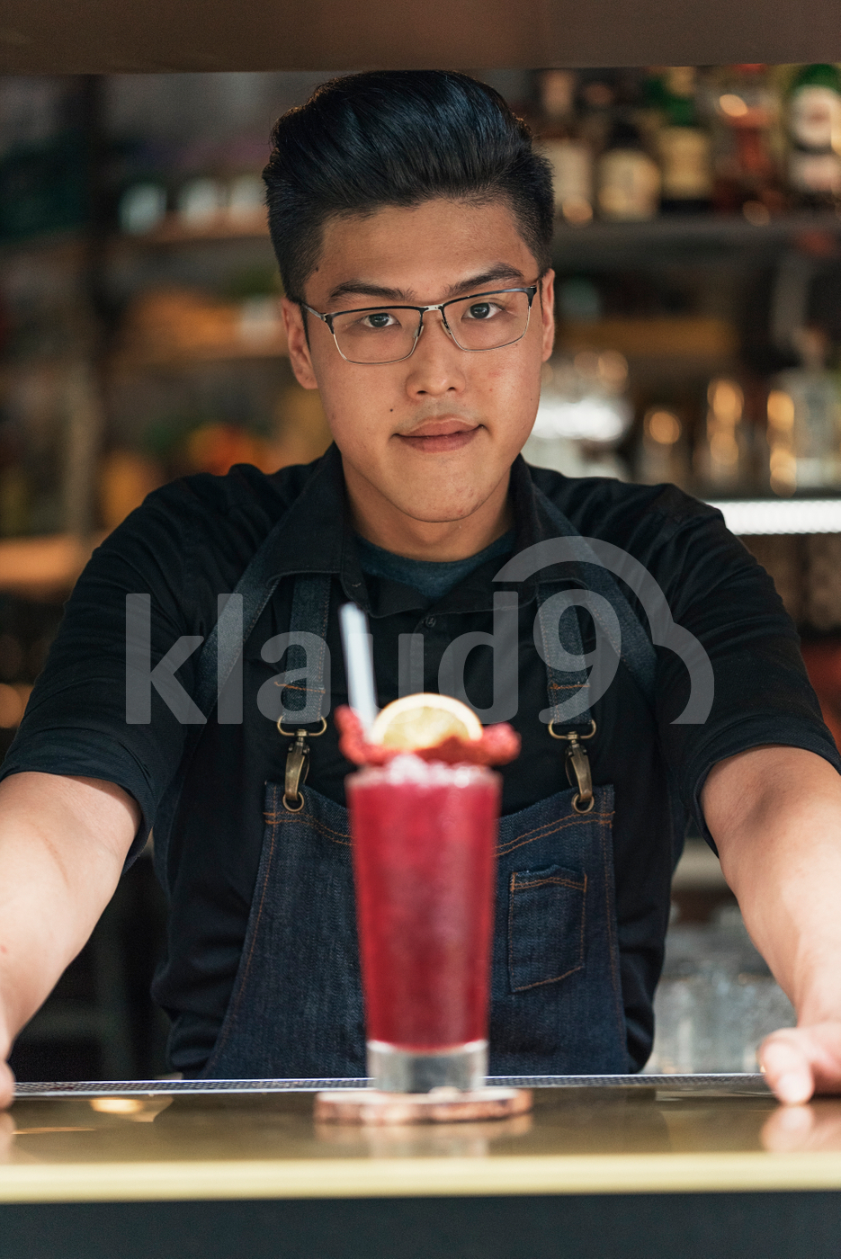 Asian bartender posing with cocktail drink