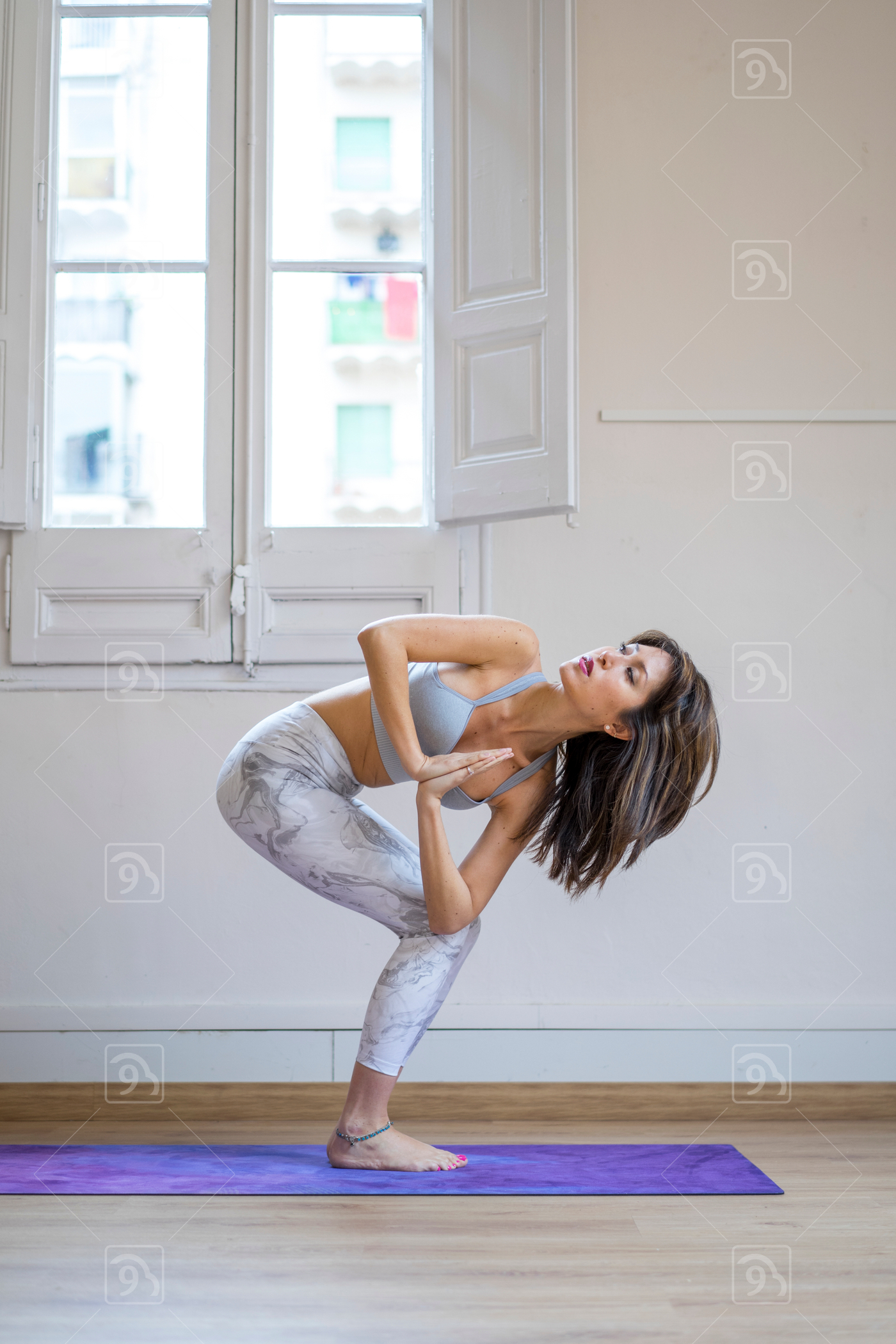 Yoga instructor doing prayer twist pose 