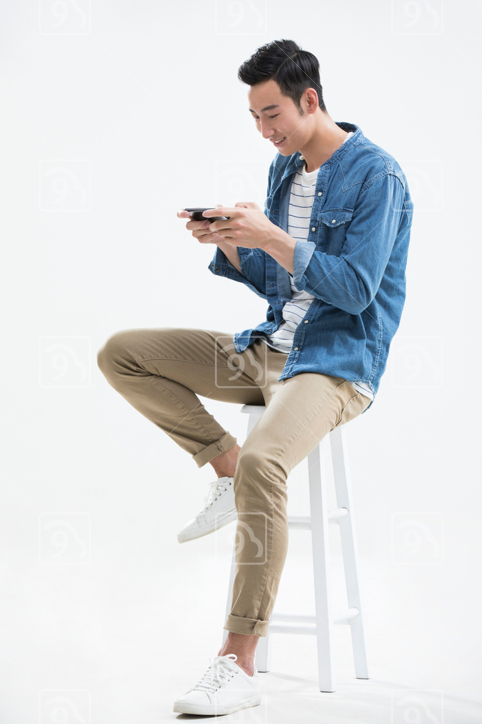 Young Chinese man playing mobile games 
