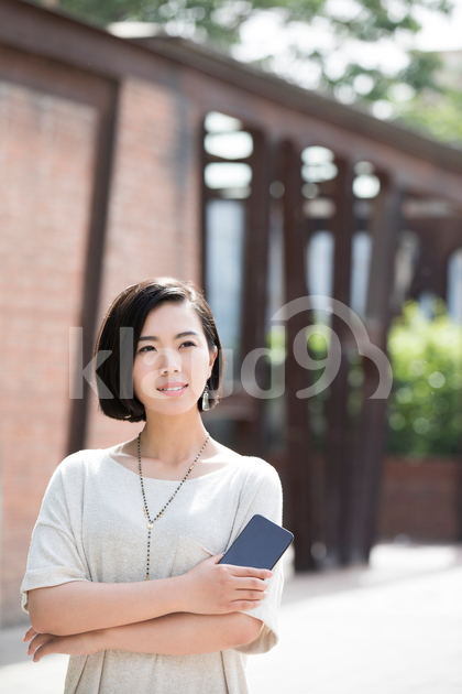 Beautiful young Chinese woman holding a smart phone