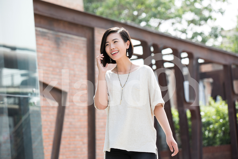Young Chinese woman talking on cell phone