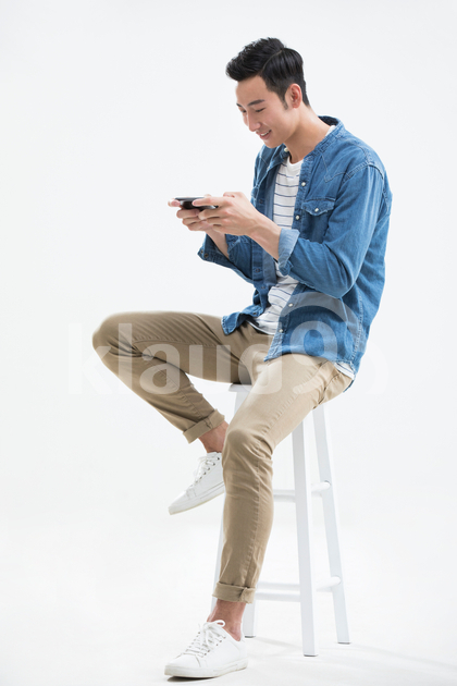 Young Chinese man playing mobile games