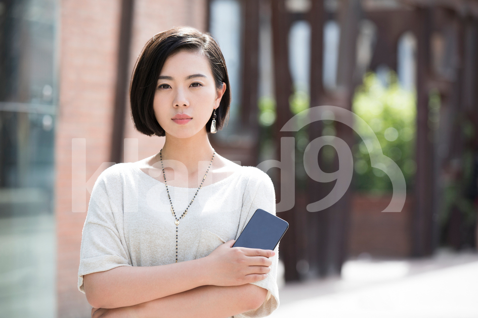 Beautiful young Chinese woman holding a smart phone