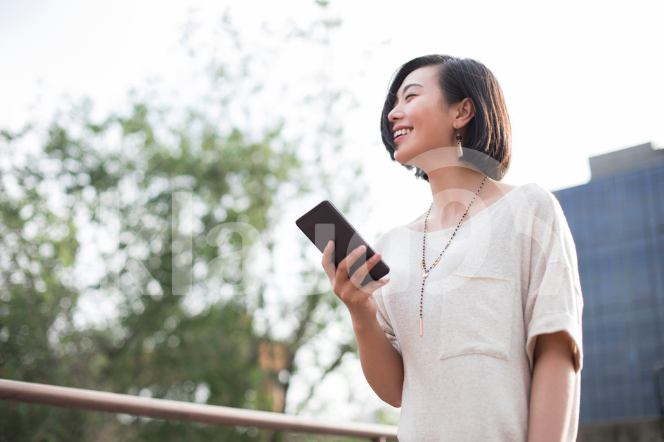 Beautiful young Chinese woman holding a smart phone