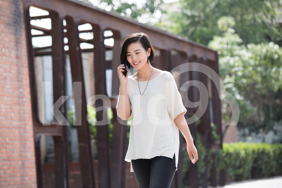 Young Chinese woman talking on cell phone
