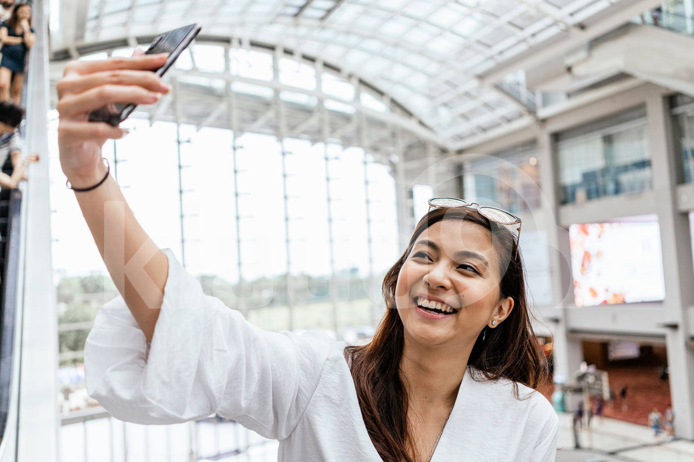 Asian woman posing for a selfie in a mall