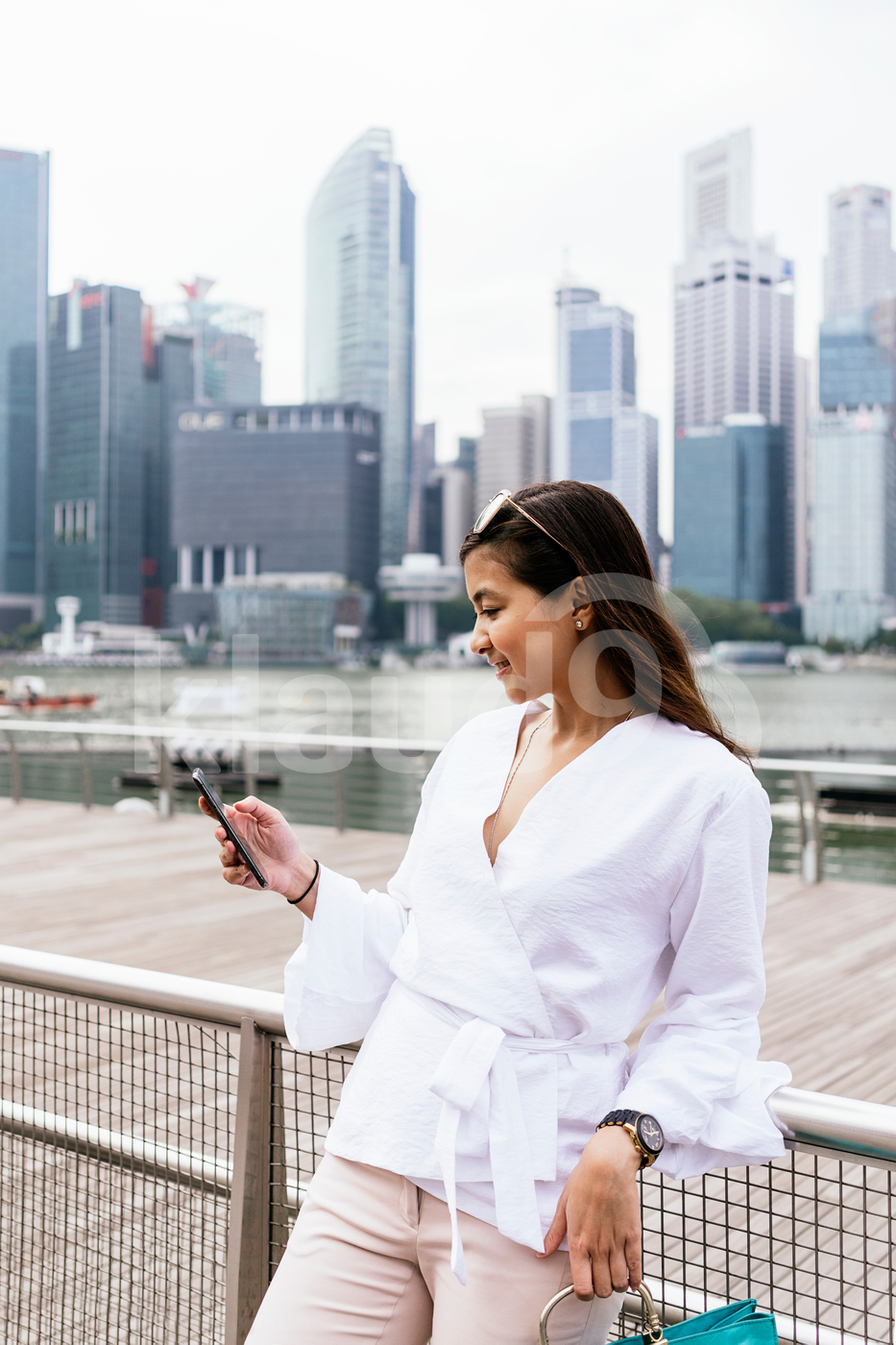 Asian woman standing outdoors using mobile